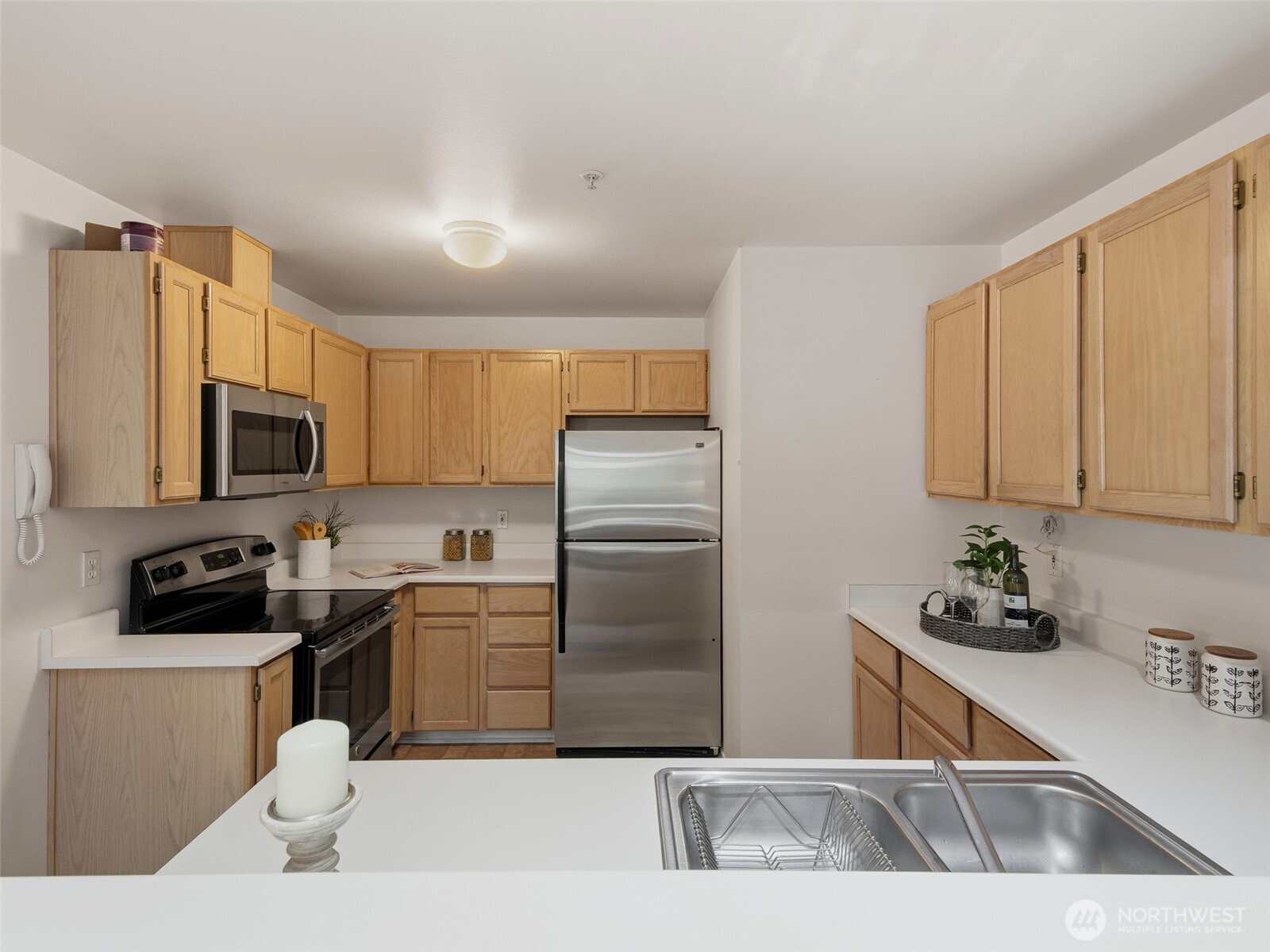 1733 Northwest 59th Street, Unit 301 Seattle, WA 98107 - Photo 9 of 35 a kitchen with stainless steel appliances a sink a refrigerator a stove a microwave and cabinets