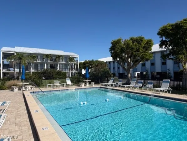 a view of a tennis ground with large trees