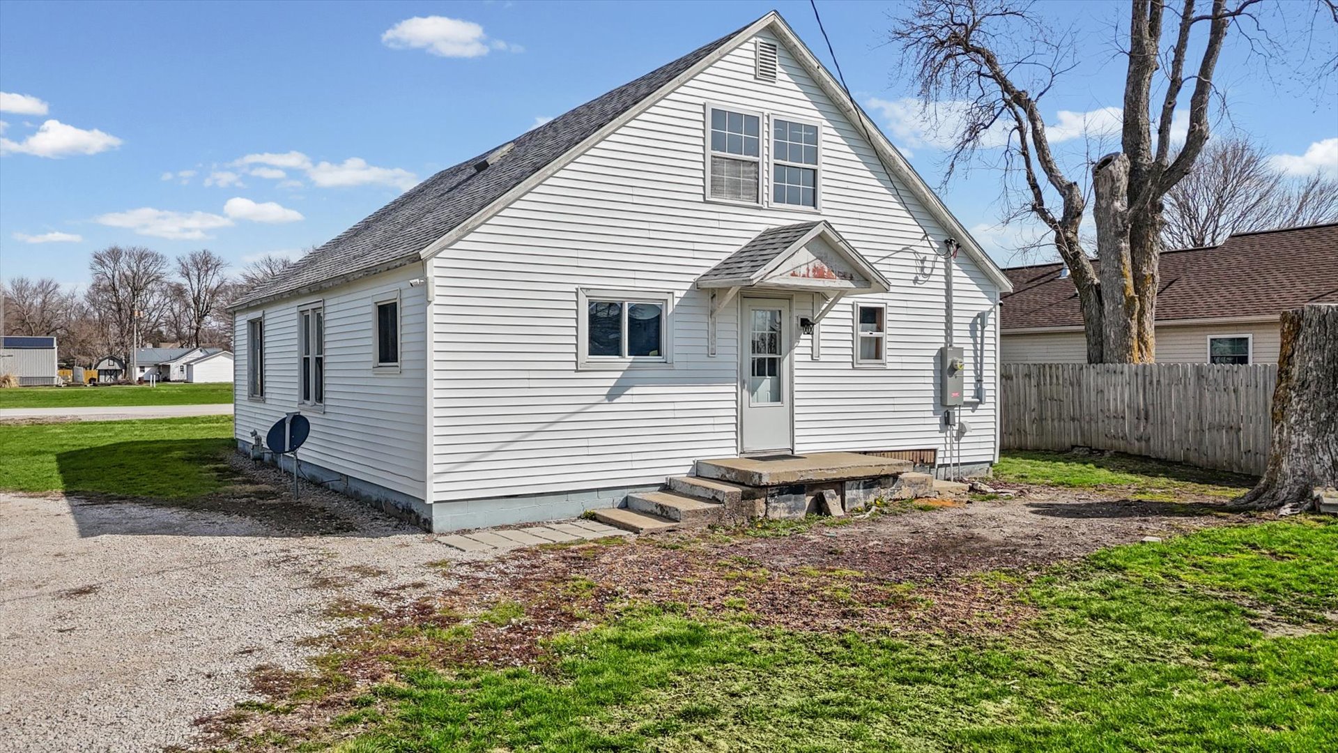 104 Allen Street Allerton, IL 61810 - Photo 30 of 33 a small white house with a white roof and table and chairs under an umbrella