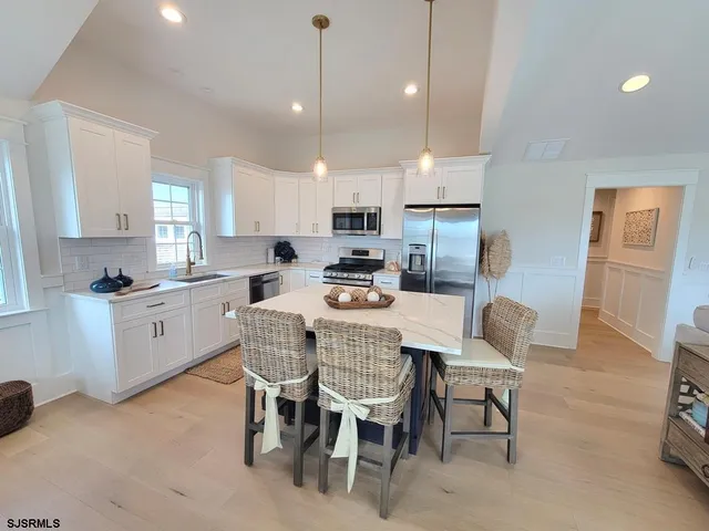 a kitchen with a dining table chairs and refrigerator
