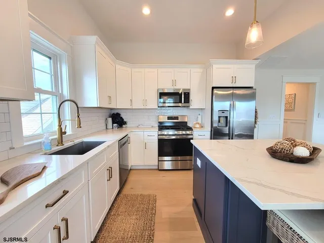 a kitchen with kitchen island a sink stove and refrigerator
