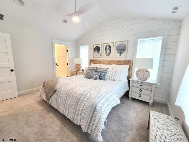a bedroom with a bed and painting on the wall