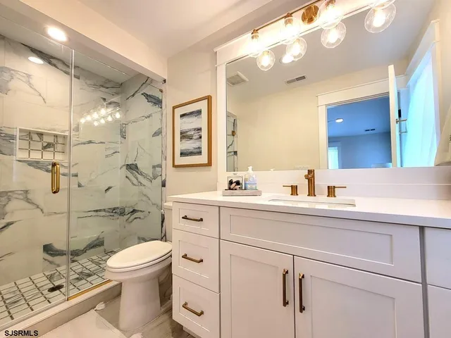 a bathroom with a sink a toilet and shower