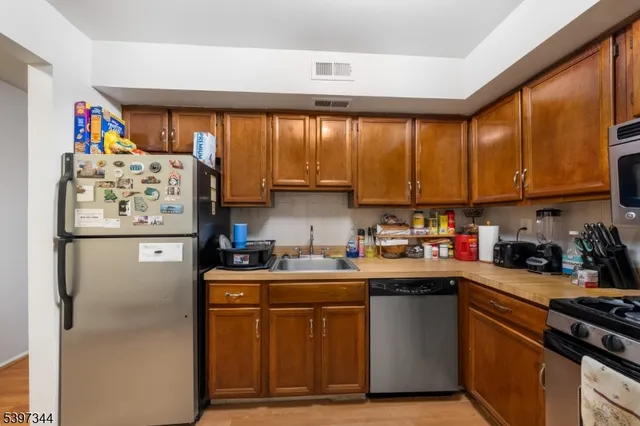 a kitchen with stainless steel appliances granite countertop a refrigerator and a sink