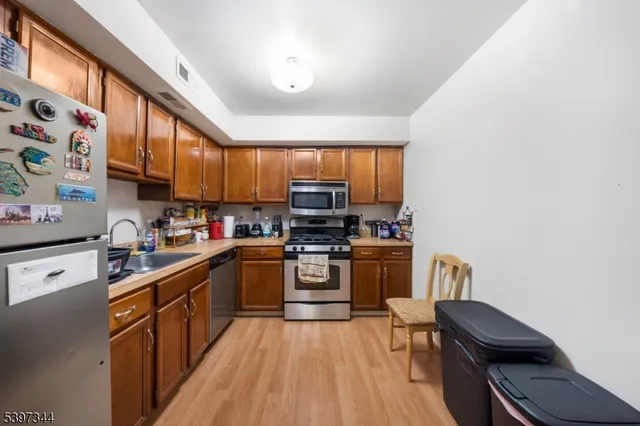 a kitchen with stainless steel appliances granite countertop a stove top oven a sink dishwasher and a microwave oven with large the oven