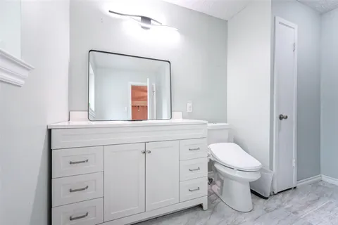 a bathroom with a sink toilet a mirror and shower
