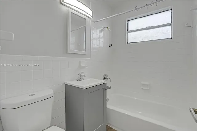 a bath room with a toilet a sink and a bath tub