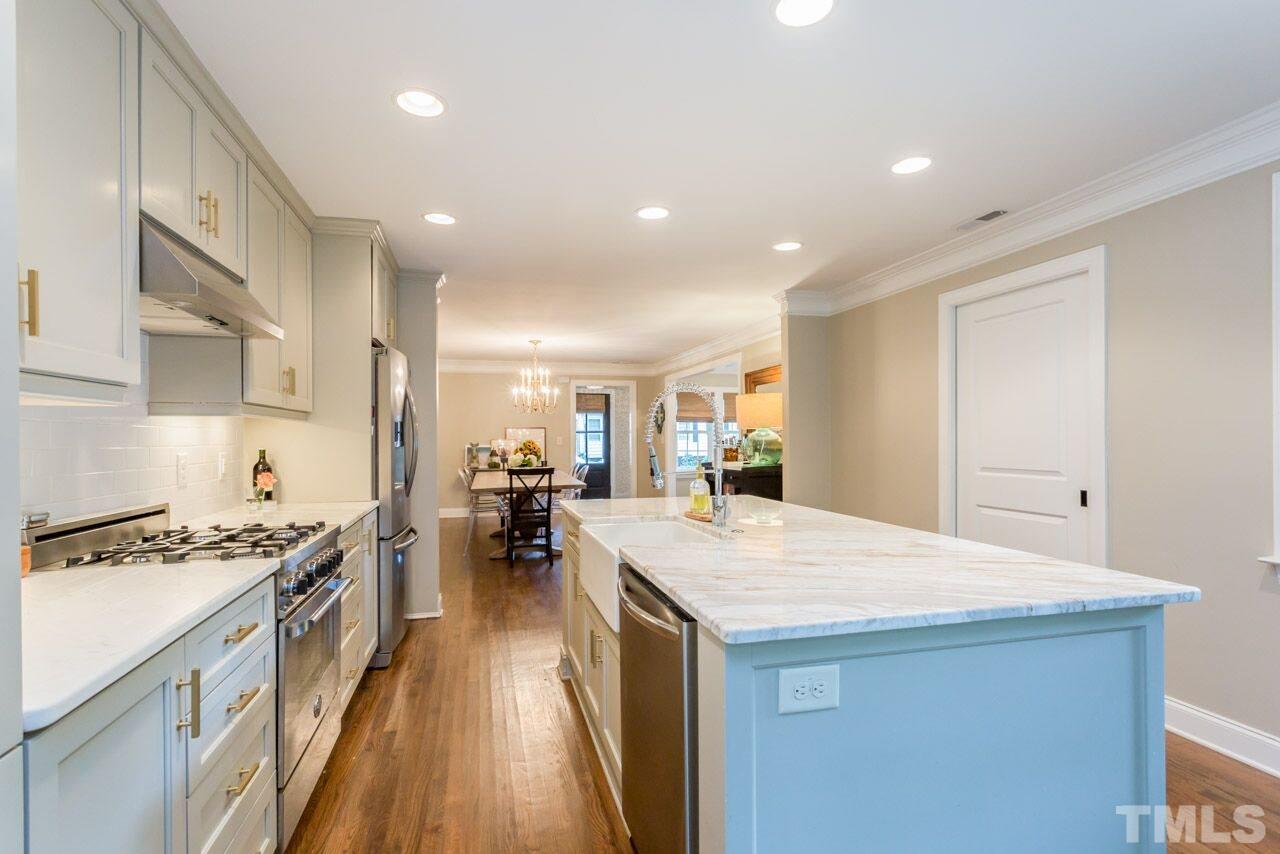 2818 Fowler Avenue Raleigh, NC 27607 - Photo 9 of 25 a kitchen with a sink stove and wooden cabinets