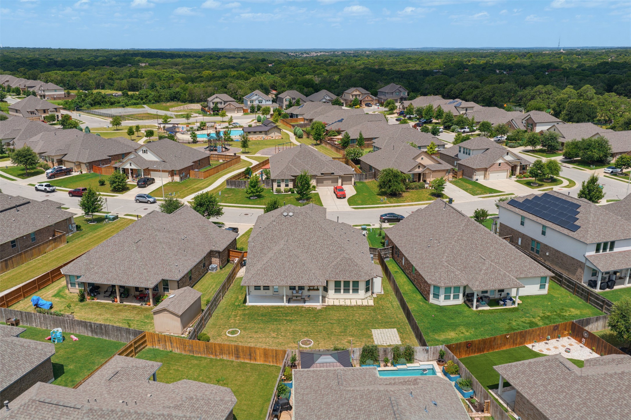 12613 Twisted Root Drive Manchaca, TX 78652 - Photo 32 of 33 An aerial perspective reveals a vibrant neighborhood with residential homes, mature trees, and a community pool.