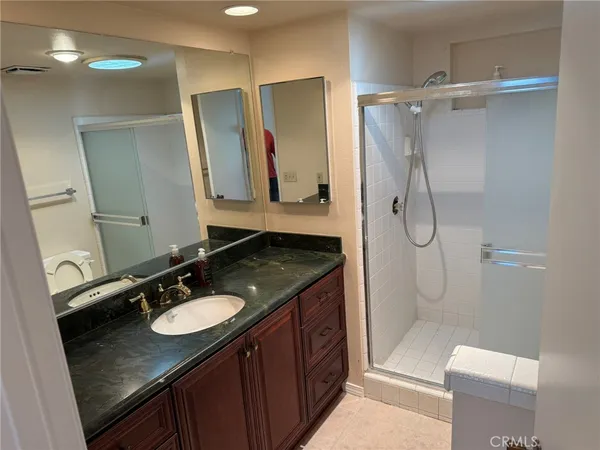 a bathroom with a granite countertop sink toilet a mirror and shower