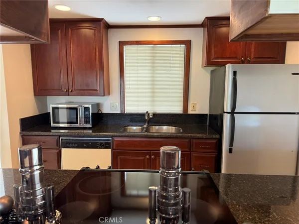 a kitchen with stainless steel appliances granite countertop a sink stove and cabinets