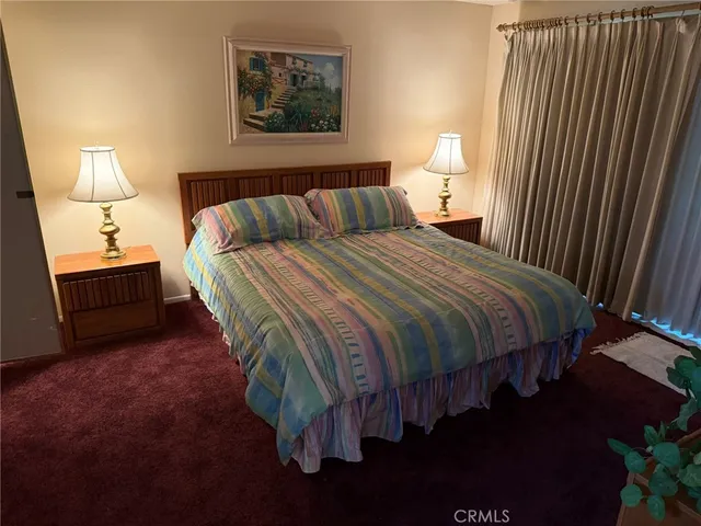 a bed sitting in a bedroom next to a lamp