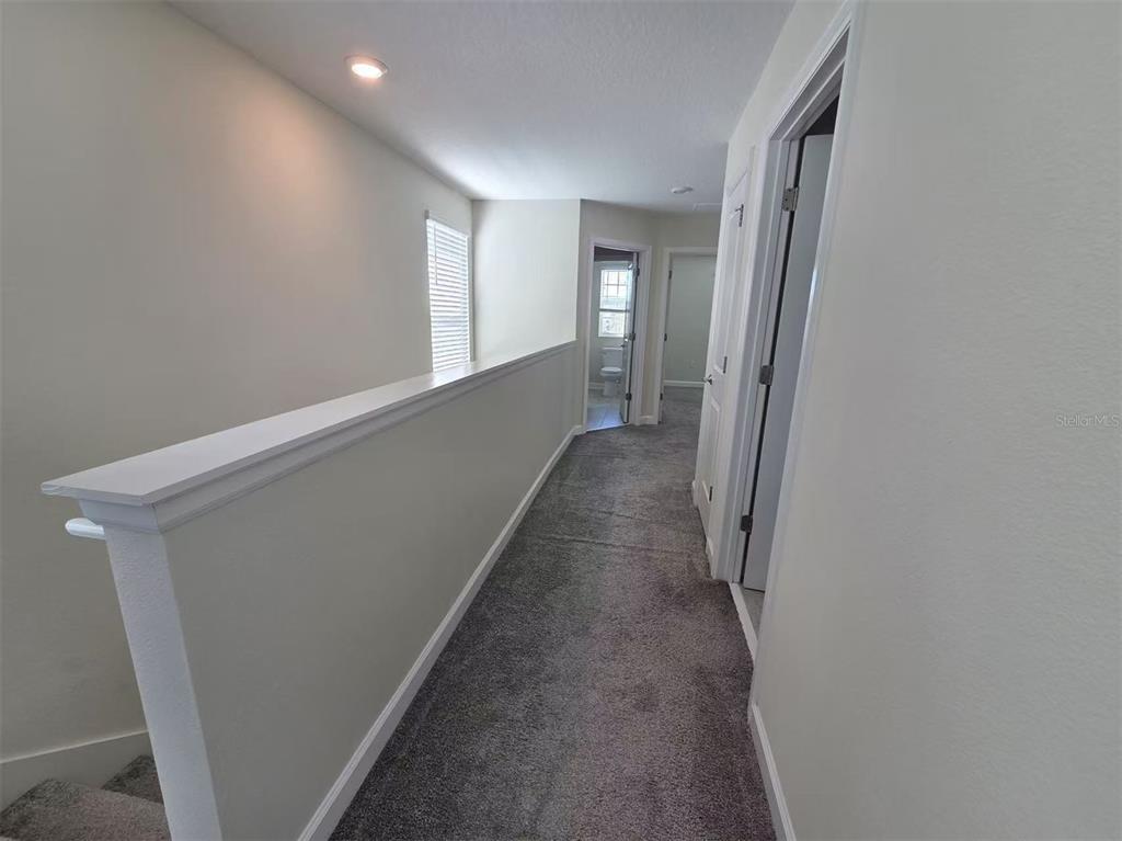 16147 Water Spring Boulevard Winter Garden, FL 34787 - Photo 6 of 17 a view of a hallway with wooden floor and staircase