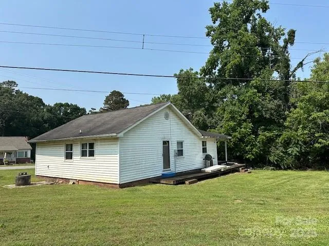 a front view of house with yard and trees in the background