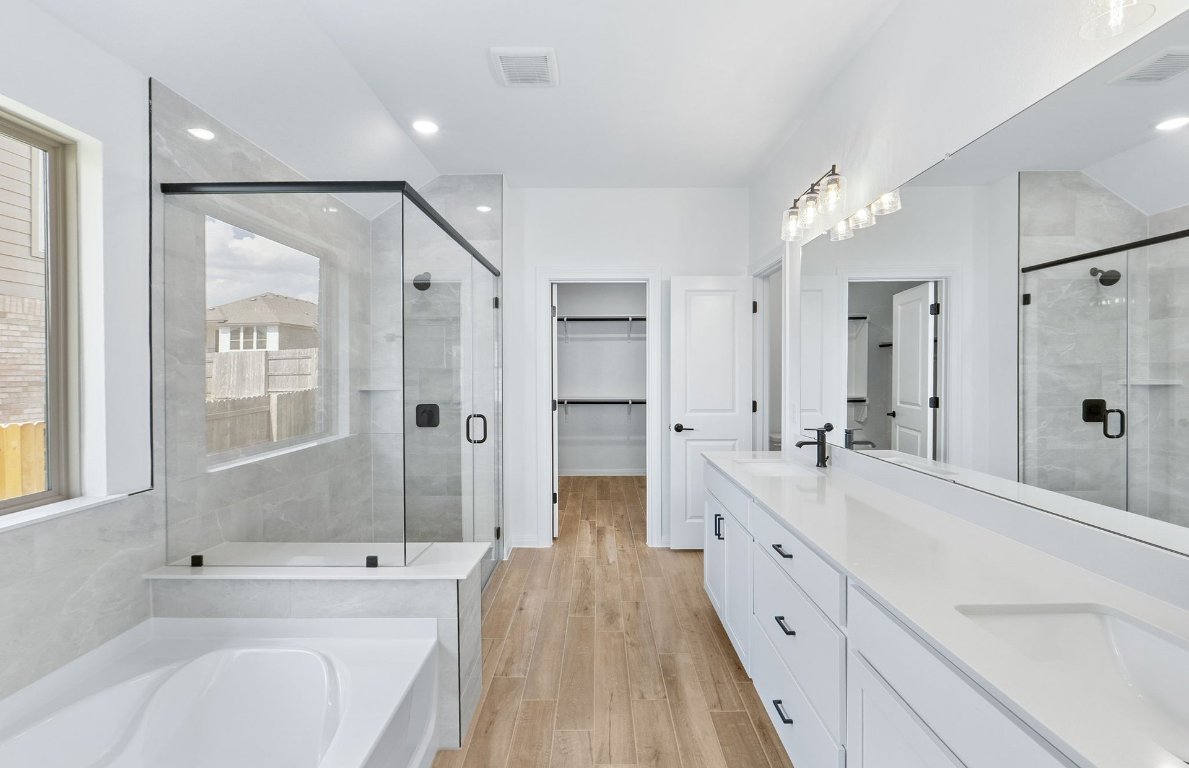 808 Crescent View Drive Georgetown, TX 78628 - Photo 7 of 19 a spacious bathroom with a double vanity sink a large mirror and a bathtub