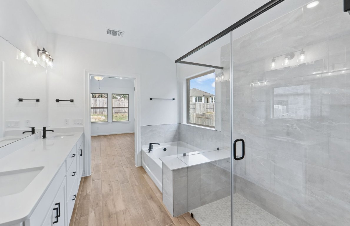 808 Crescent View Drive Georgetown, TX 78628 - Photo 8 of 19 a bathroom with a tub sink double vanity and a mirror