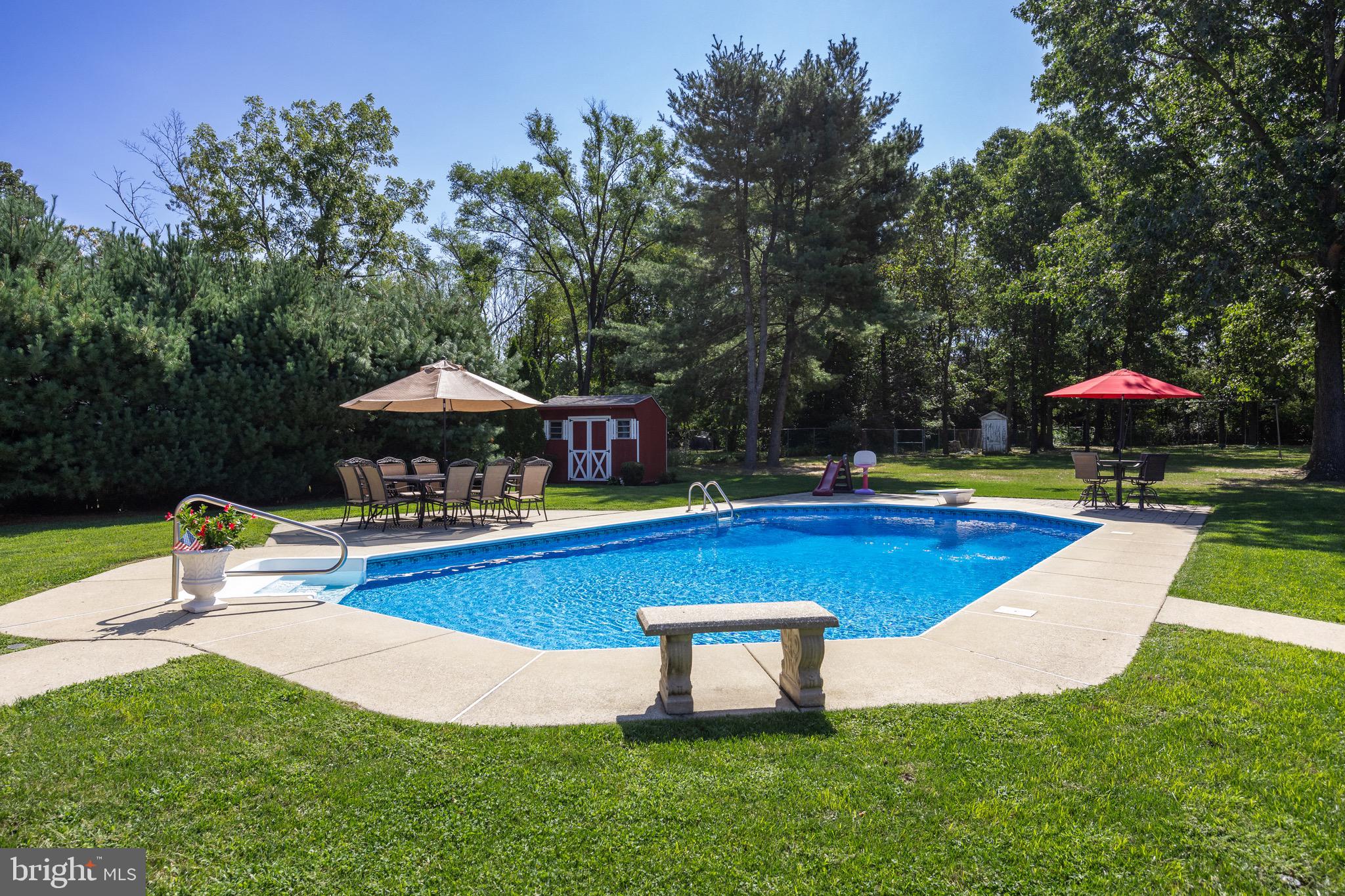 10 Cedar Brook Road Sicklerville, NJ 08081 - Photo 44 of 52 a view of a swimming pool with lawn chairs under an umbrella