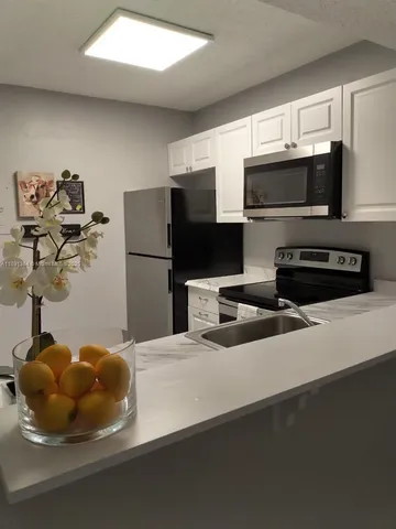 a kitchen with stainless steel appliances a refrigerator sink and microwave