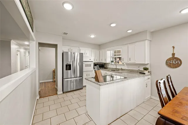 a kitchen with stainless steel appliances granite countertop a refrigerator and a stove top oven