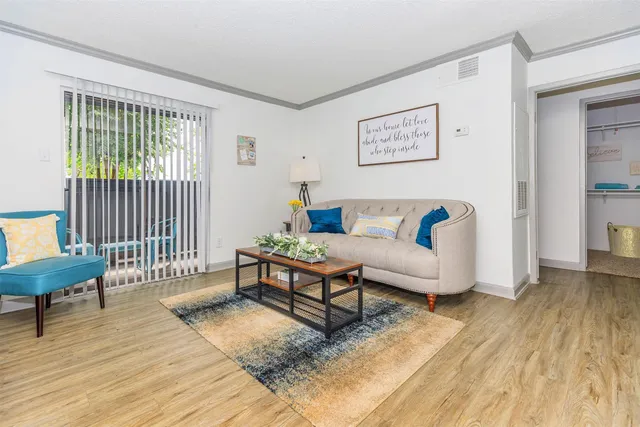 a living room with furniture and a wooden floor