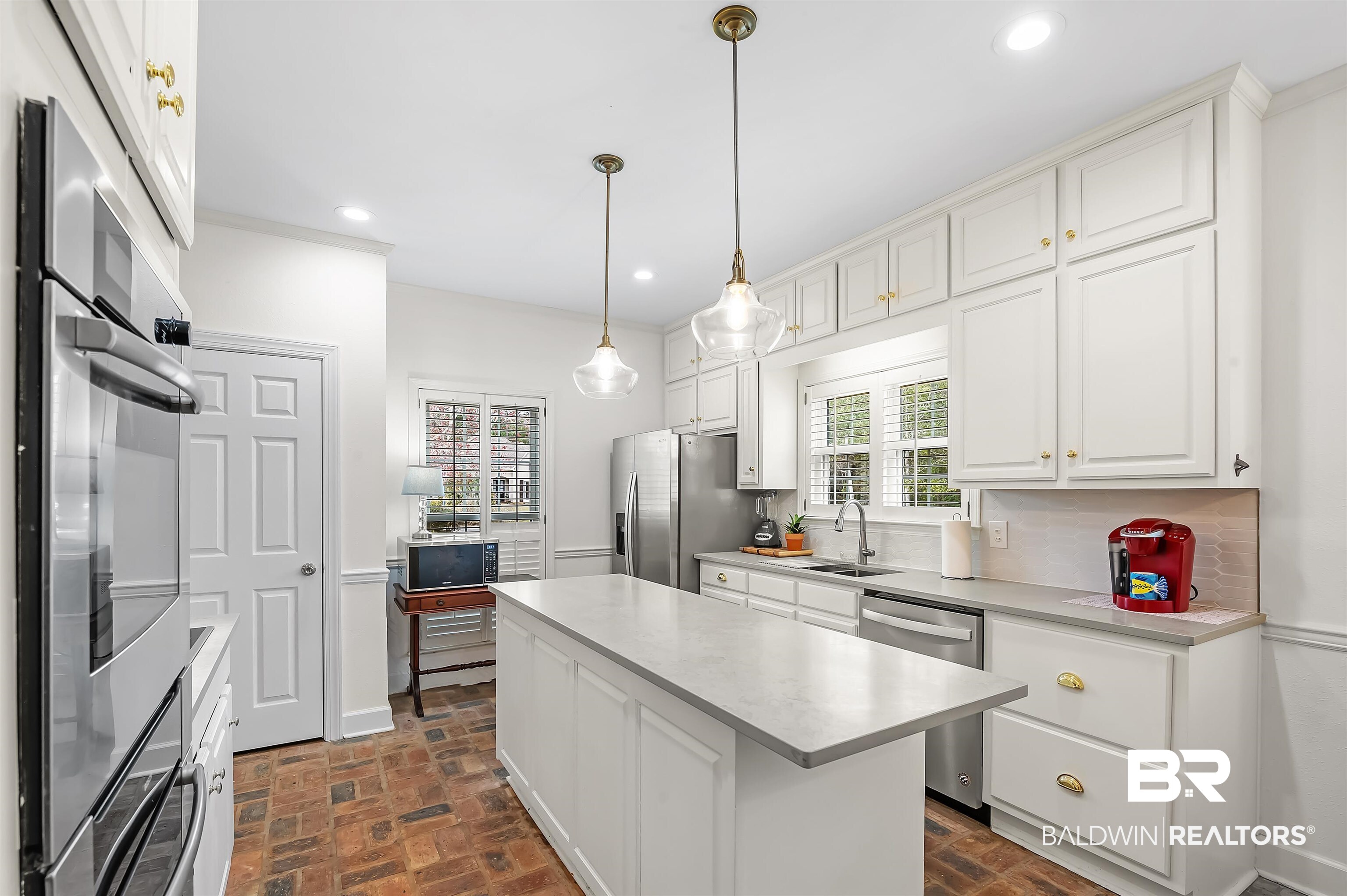 8915 Bay Point Drive Elberta, AL 36530 - Photo 39 of 74 Kitchen with brick floor, recessed lighting, white cabinetry, appliances with stainless steel finishes, and a center island