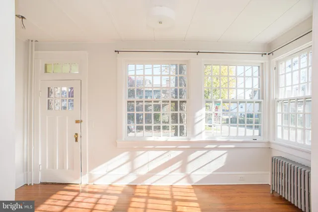 a view of a bedroom with wooden floor and a window