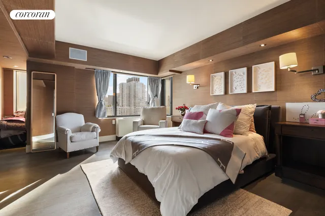 a spacious bedroom with a bed couch and window