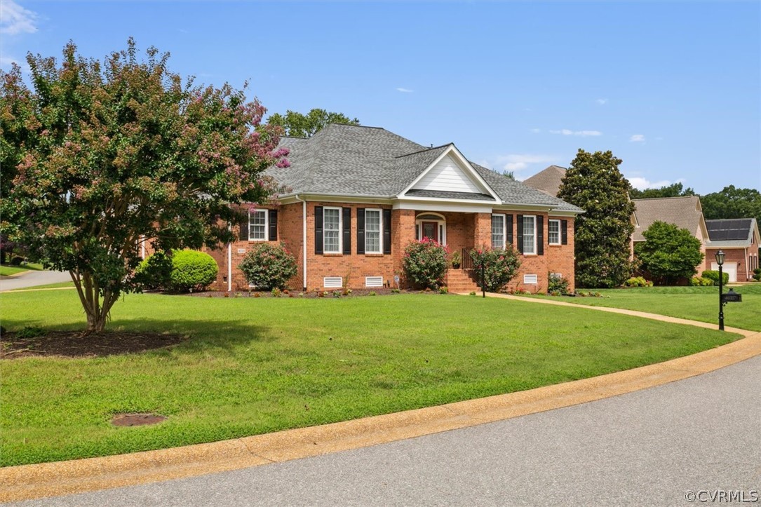 a front view of a house with a garden and trees