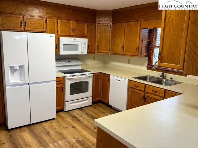 a kitchen with stainless steel appliances granite countertop a sink a stove and refrigerator
