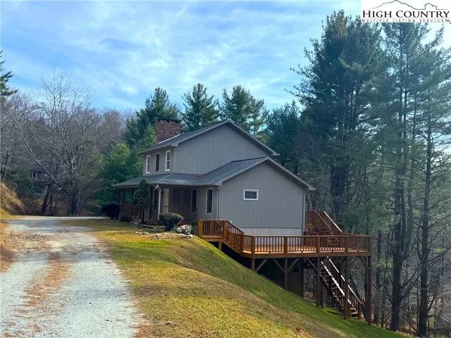 a view of a house with pool and a yard