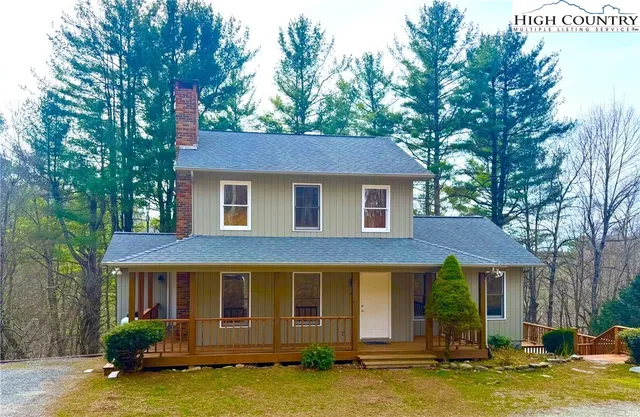 a front view of a house with a garden and trees