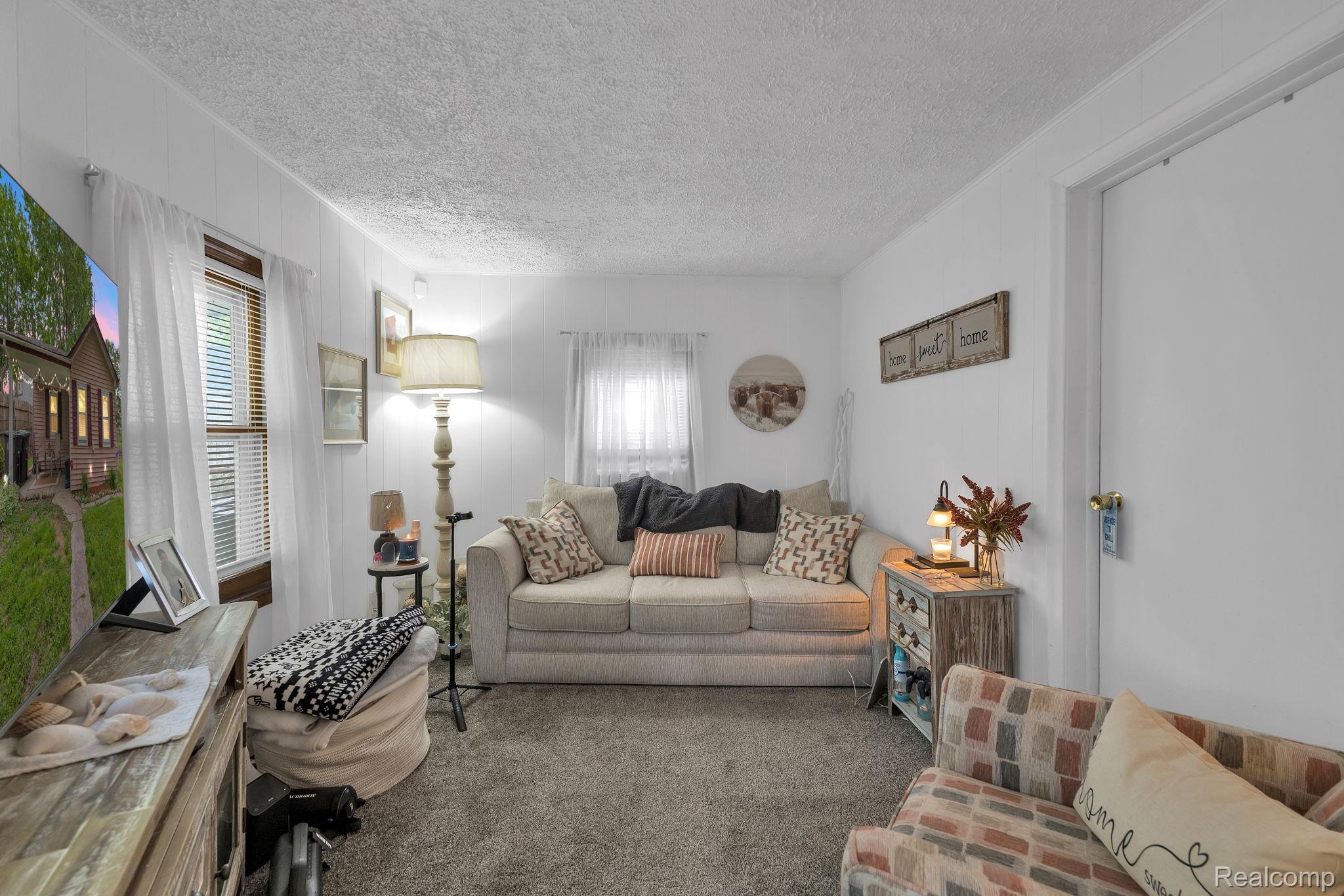 11063 Jackson Street Taylor, MI 48180 - Photo 10 of 27 Carpeted living space featuring white vertical paneling and a textured ceiling