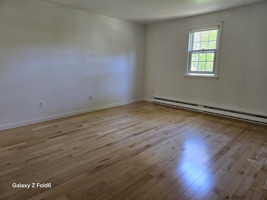 222 Buck Island Road, Unit 45 Yarmouth, MA 02673 - Photo 15 of 23 an empty room with wooden floor and windows
