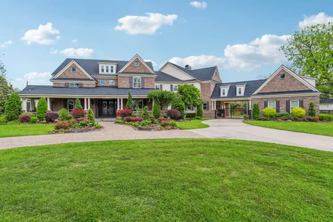 a front view of a residential houses with yard and green space