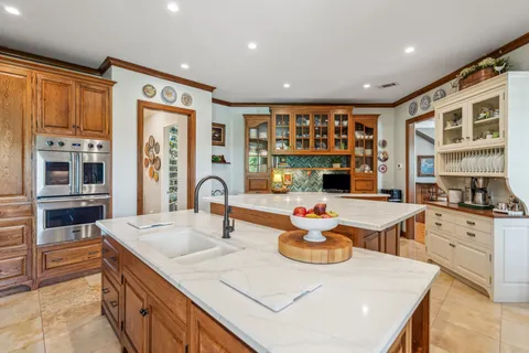 a kitchen with stainless steel appliances granite countertop a stove a sink and a refrigerator
