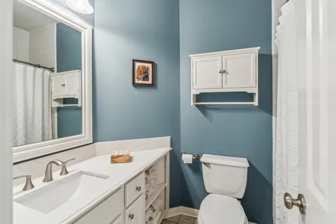 a bathroom with a toilet sink and mirror