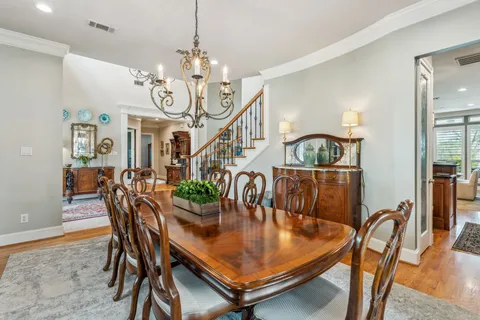 a dining room with furniture a chandelier and wooden floor