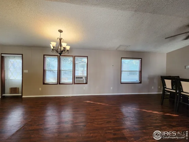 a view of a livingroom with furniture wooden floor fireplace and windows