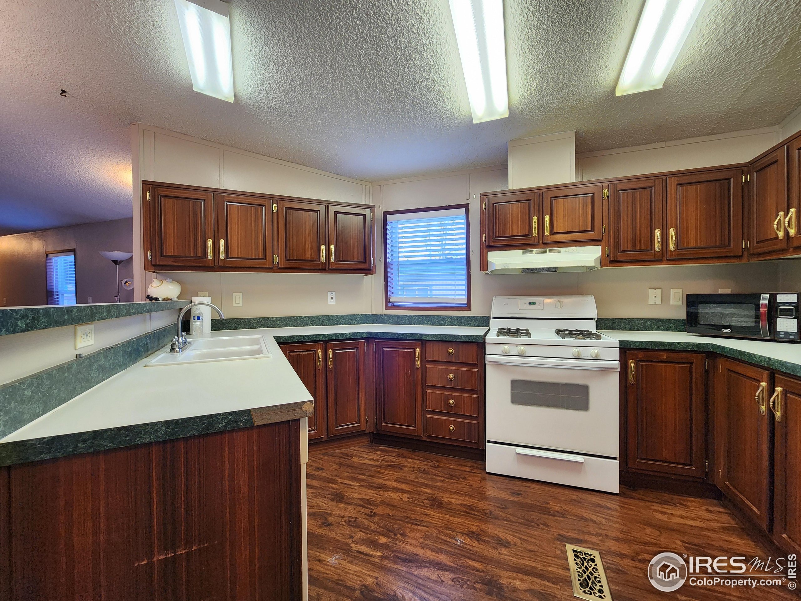 5000 Butte Street, Unit 208 Boulder, CO 80301 - Photo 3 of 37 a kitchen with stainless steel appliances granite countertop a sink stove cabinets and wooden floor