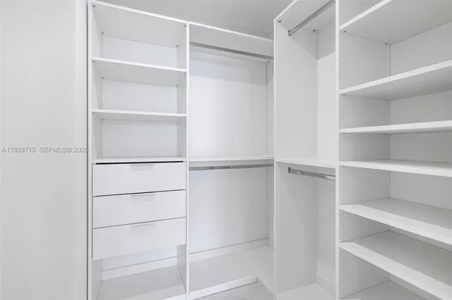 a view of walk in closet with empty racks