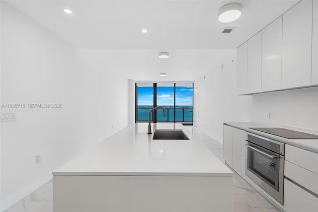 a kitchen with a sink a stove and cabinets