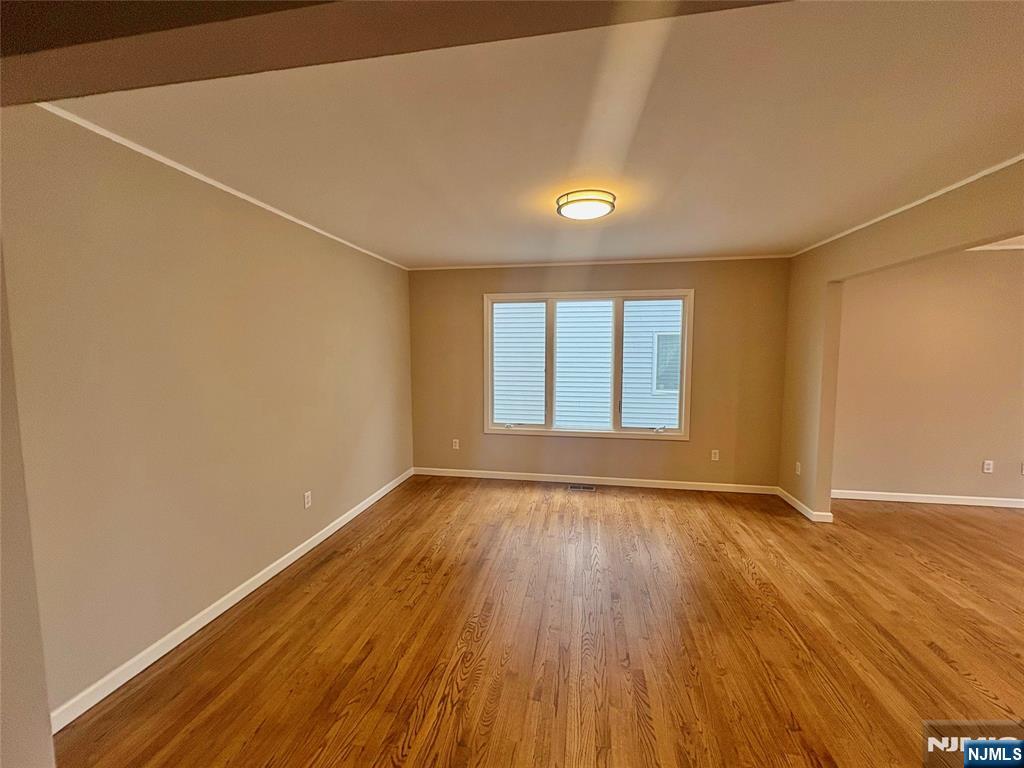 32 Orchard Street Garfield, NJ 07026 - Photo 2 of 14 an empty room with wooden floor and windows