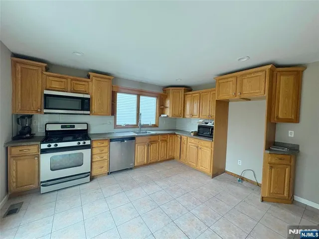 a kitchen with stainless steel appliances granite countertop a refrigerator and a stove top oven