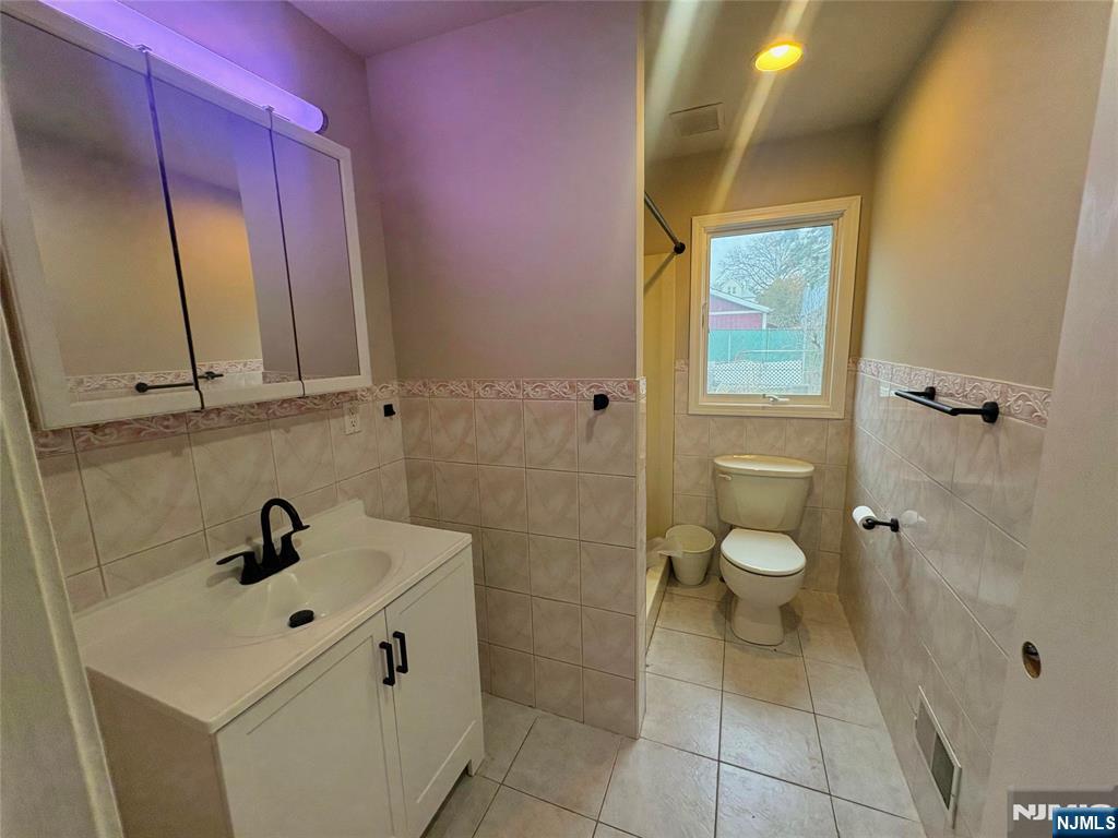 32 Orchard Street Garfield, NJ 07026 - Photo 5 of 14 a bathroom with a sink mirror and toilet