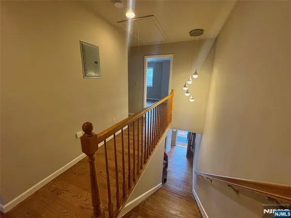 a view of a hallway with wooden floor and staircase