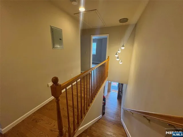 a view of a hallway with wooden floor and staircase