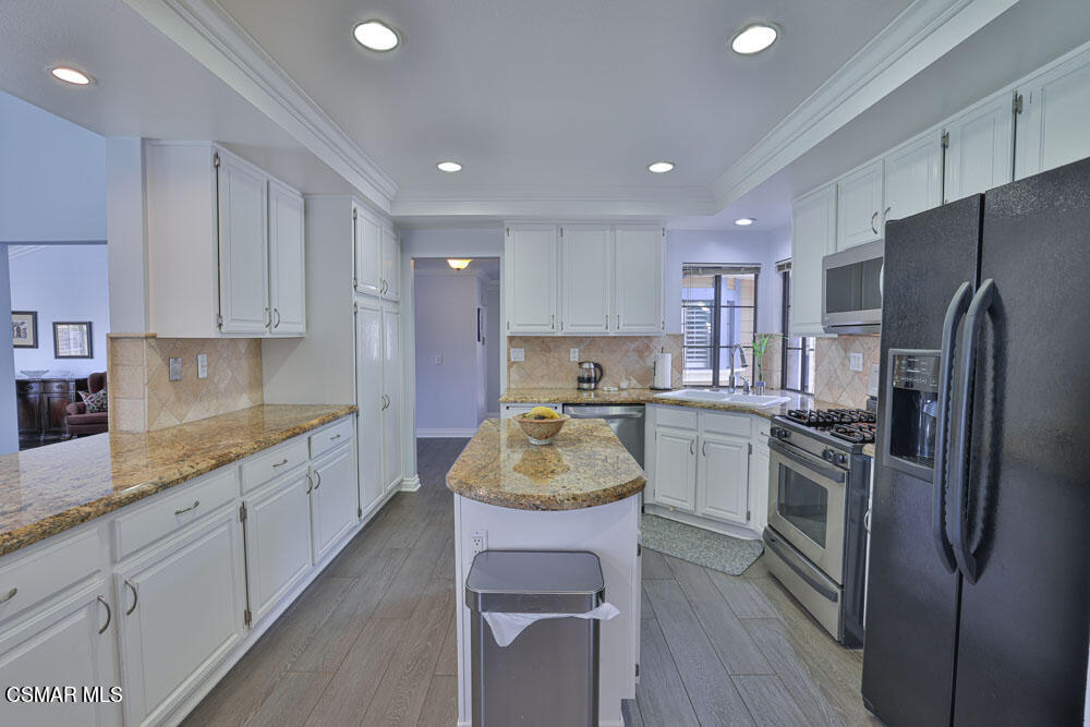 3920 Southhampton Road Moorpark, CA 93021 - Photo 10 of 41 a kitchen with white cabinets and stainless steel appliances