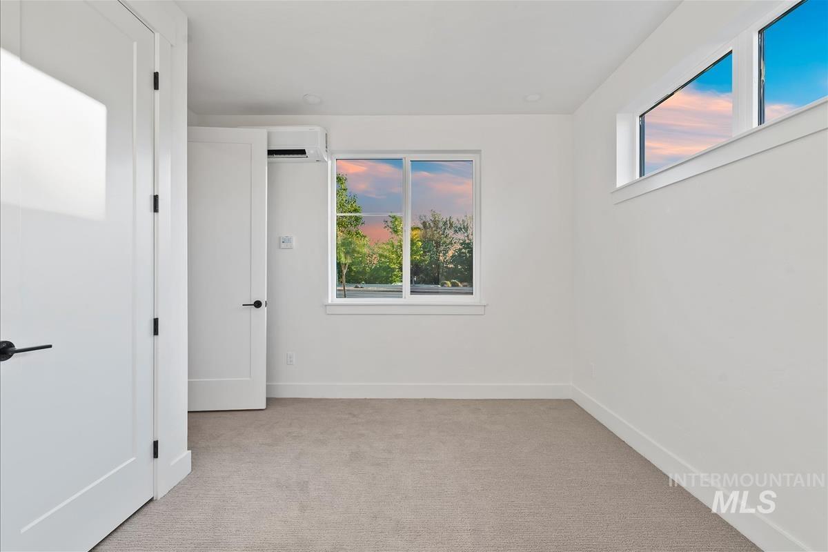 3219 West Moore Street Boise, ID 83702 - Photo 30 of 36 Bright room featuring a large window, high transom window, and light-colored carpeting