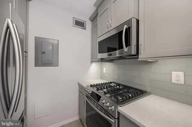 a kitchen with stainless steel appliances a stove a microwave and a sink