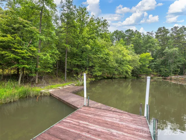 a wooden pier with boats in a lake